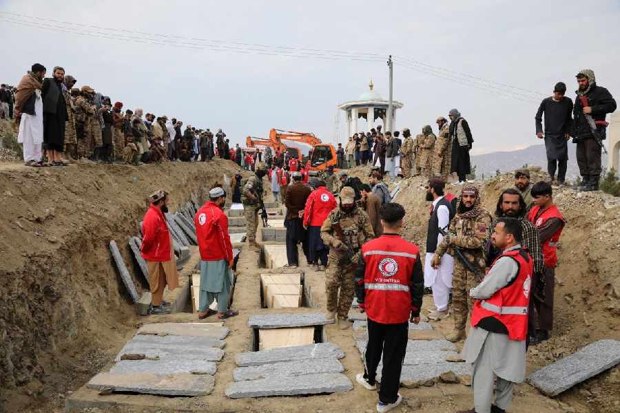 Coffins are placed in a grave during a second mass funeral for victims of an airstrike on a drug rehabilitation center earlier this month, in Kabul, Afghanistan, Thursday, March 26, 2026.
