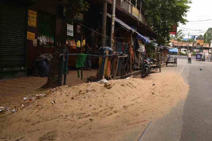 Heaps of sand along Surya Sen Street and (right) Prince Anwar Shah Road on Sunday. Pictures by Bishwarup Dutta
