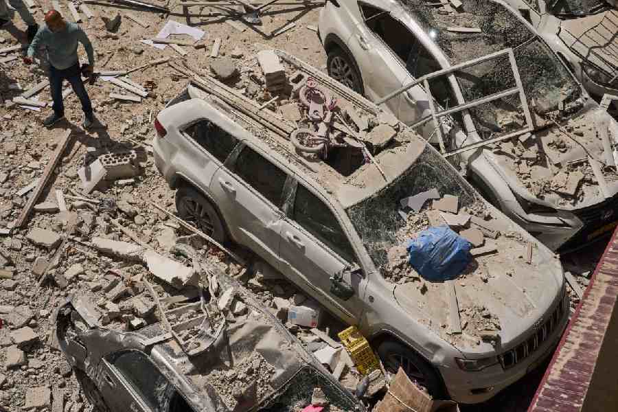 A man inspects the damage to cars and an apartment building struck by an Iranian missile in Ramat Gan, Israel, Monday, April 6, 2026.