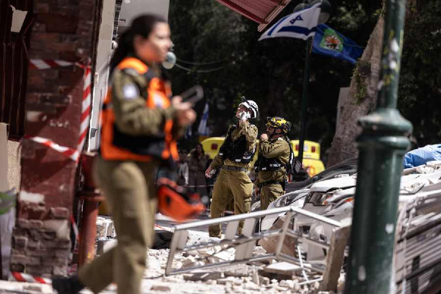 Emergency personnel work at an impact site, following a barrage of missiles launched from Iran, amid the U.S.-Israeli conflict with Iran, in central Israel, April 6, 2026.