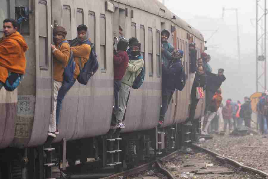 Passengers on a train as it approaches a station in New Delhi on January 8, 2024. 