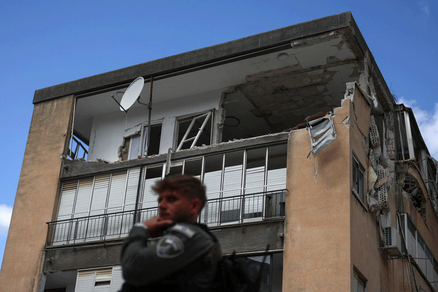 A member of Israeli security forces next to a damaged building at an impact site, following a barrage of missiles launched from Iran, amid the U.S.-Israeli conflict with Iran, in central Israel, April 6, 2026.