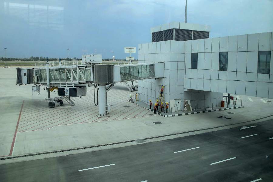 Workers carry out work near the aerobridge at Noida International Airport, in Jewar, Uttar Pradesh, Tuesday, April 7, 2026.