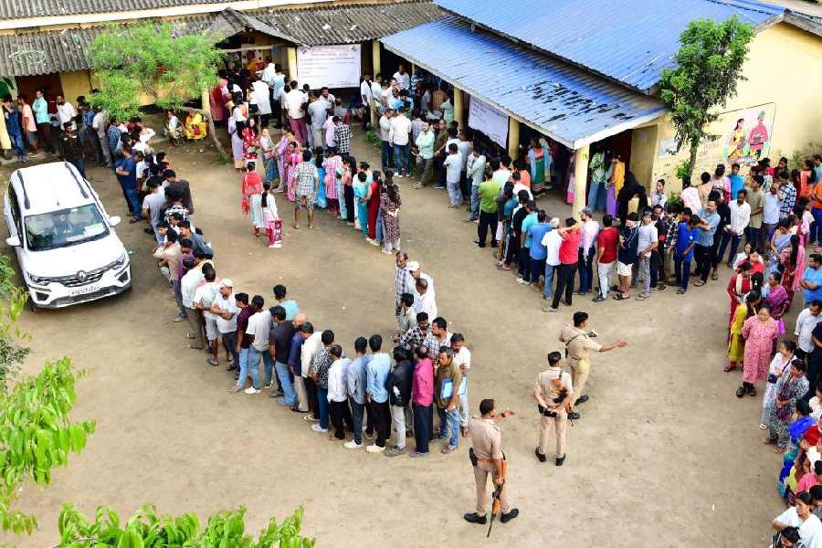 People wait in queues to cast their votes during the Assam Assembly elections, at a polling station at Bonda, in Guwahati, Thursday, April 9, 2026.