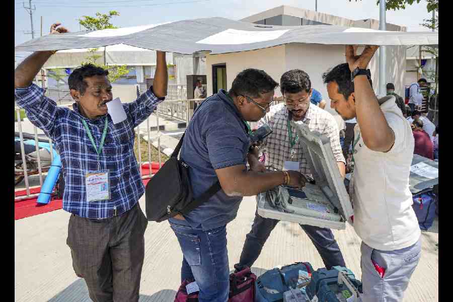 Polling officials check election material at a distribution centre in Guwahati on Wednesday. (PTI)