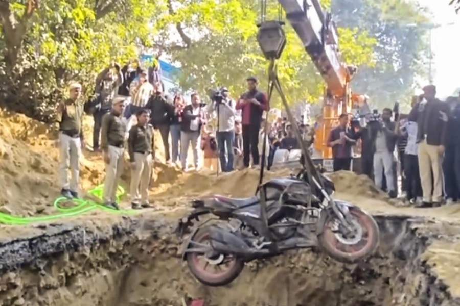 The bike of a motorcyclist who plunged into an uncovered pit dug for construction work by Delhi Jal Board, being lifted out, at Janakpuri, in New Delhi, Friday, Feb. 6, 2026.