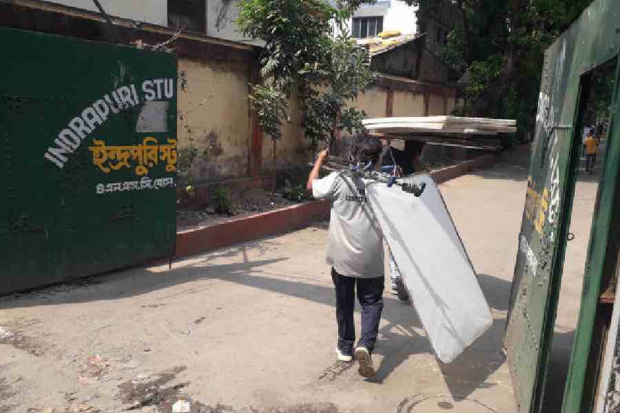 A worker carries shoot equipment at Indrapuri Studiosin Tollygunge earlier this week. Picture by Bishwarup Dutta