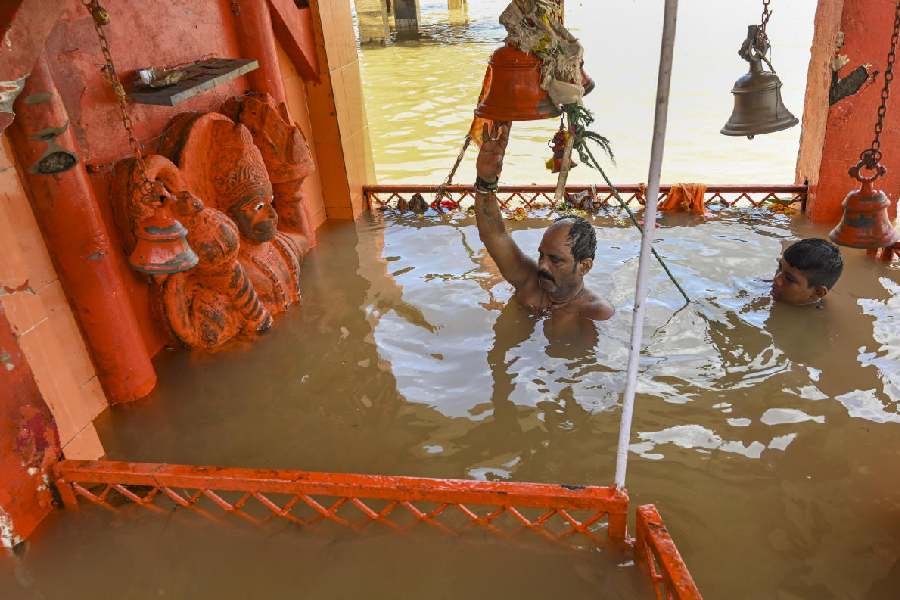 People offer prayers while wading through neck-deep floodwater of the swollen Narmada river inundating a temple on the first day of 'Pitru Paksha', in Jabalpur, Madhya Pradesh.