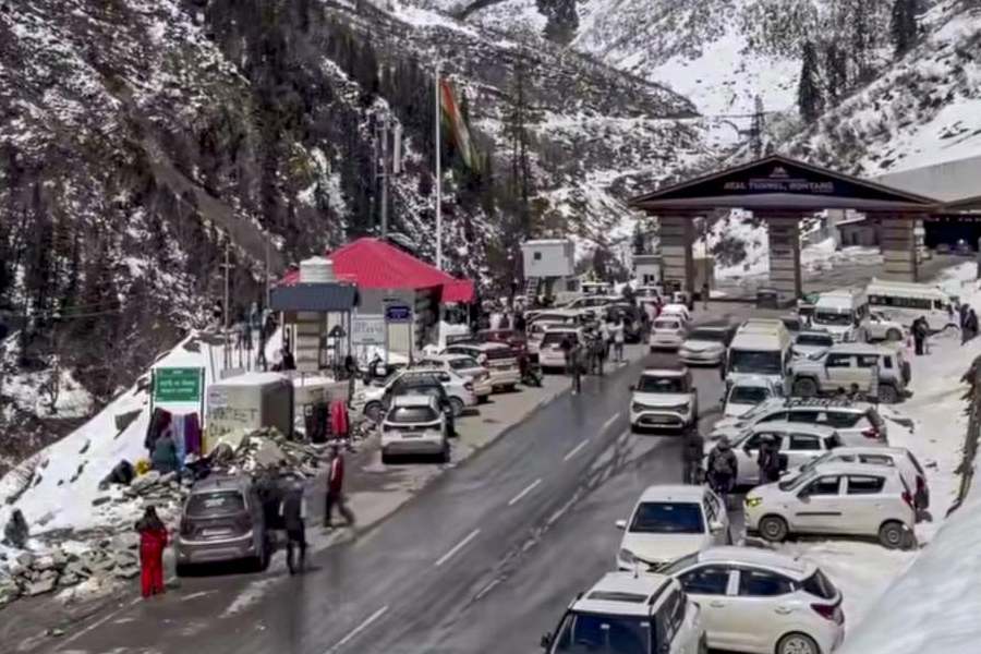 Vehicles move amid fresh snowfall near the Atal Tunnel South Portal, with snow-clad mountains in the backdrop, in Manali, Himachal Pradesh, Friday, April 10, 2026.