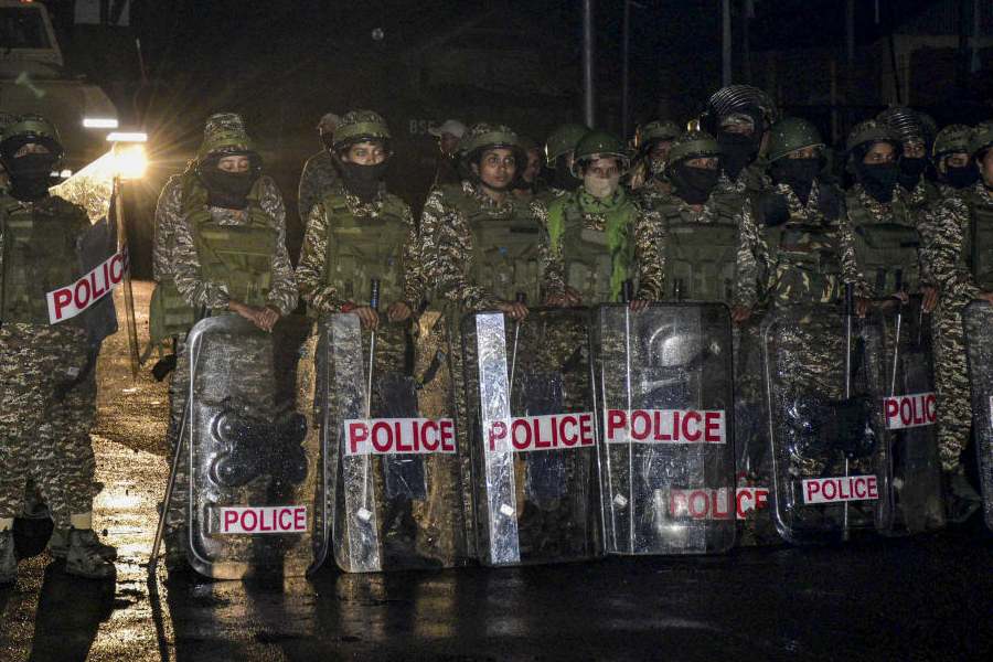Security personnel stand guard amid protests across the state against the Bishnupur bomb attack that killed two children, at Lamlong area, in Imphal East district, Manipur, late Thursday, April 9, 2026.