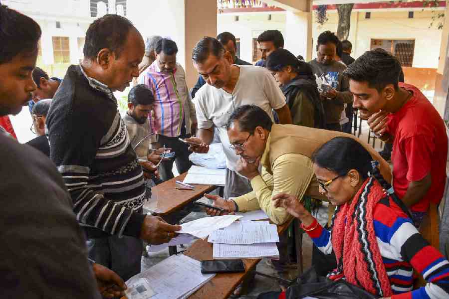 A government official looks at his phone in a voter camp