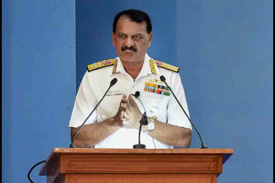 Admiral Dinesh K Tripathi speaking to a microphone