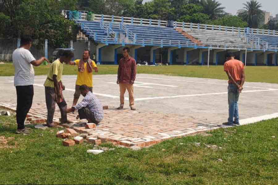 Workers at the temporary helipad in the Raiganj Stadium on Monday. Picture by Kousik Sen