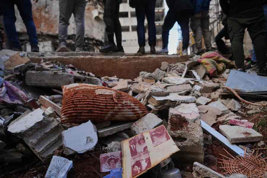 Photographs lie amid debris at the site of a building where search efforts continue for missing woman Zahraa Aboud, 26, after it was destroyed in an Israeli airstrike on Wednesday in central Beirut, Sunday, April 12, 2026.