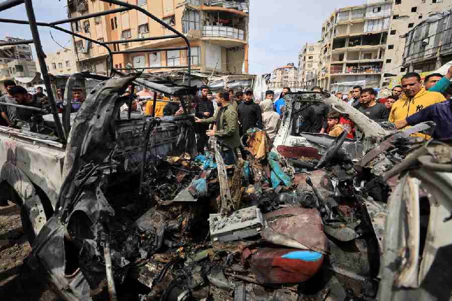 Palestinians inspect the damage after an Israeli strike targeted a police vehicle in Gaza City, according to medics, in Gaza City, April 14, 2026.