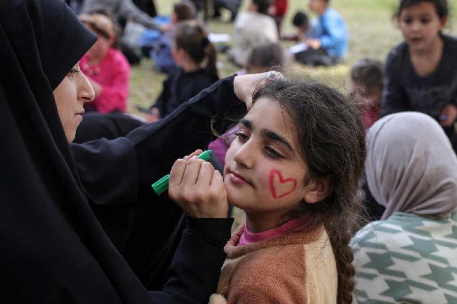 A girl gets face paint as part of activities organised by Takatafo Campaign and supported by psychologists, to entertain and to mentally support displaced children, in a shelter in Tyre, south Lebanon, April 14, 2026.