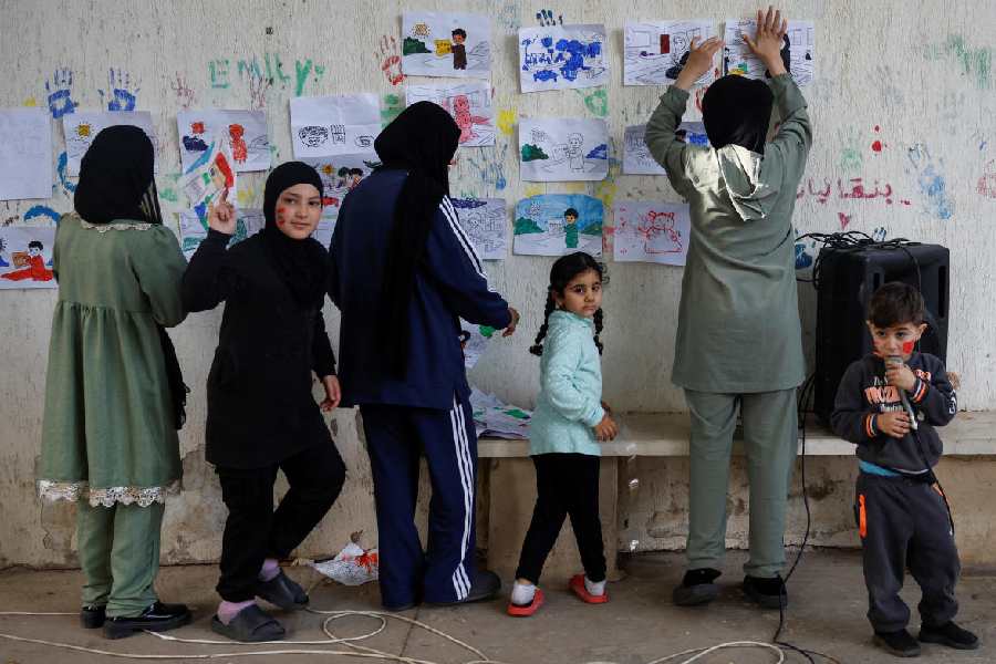 Displaced children put their paintings on a wall, after taking part in activities organised by Takatafo Campaign and supported by psychologists, to entertain and to mentally support displaced children, in a shelter in Tyre, south Lebanon, April 14, 2026.
