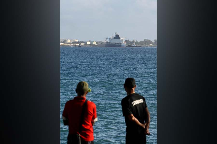 People watch as Anatoly Kolodkin, a Russian-flagged oil tanker carrying some 700,000 barrels of crude, marking the first significant oil delivery since the administration of US President Donald Trump cut off Cuba's fuel supply, is moored while being assisted by tugboats, at Matanzas oil terminal, in Matanzas, Cuba, March 31, 2026.