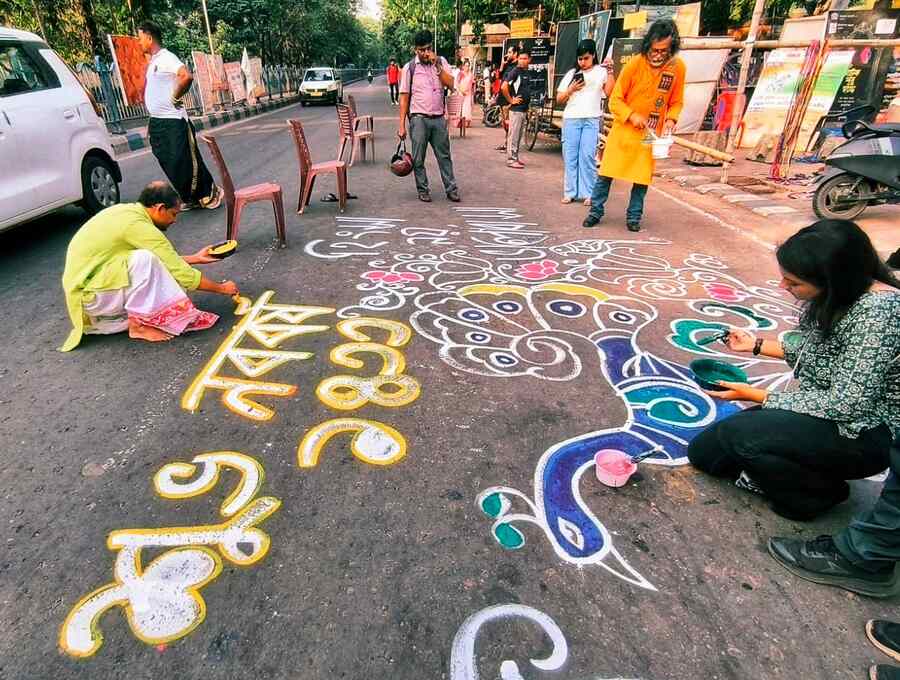 Outside Academy of Fine Arts, the street turned into a canvas as artists painted colourful alpona to welcome the new year.