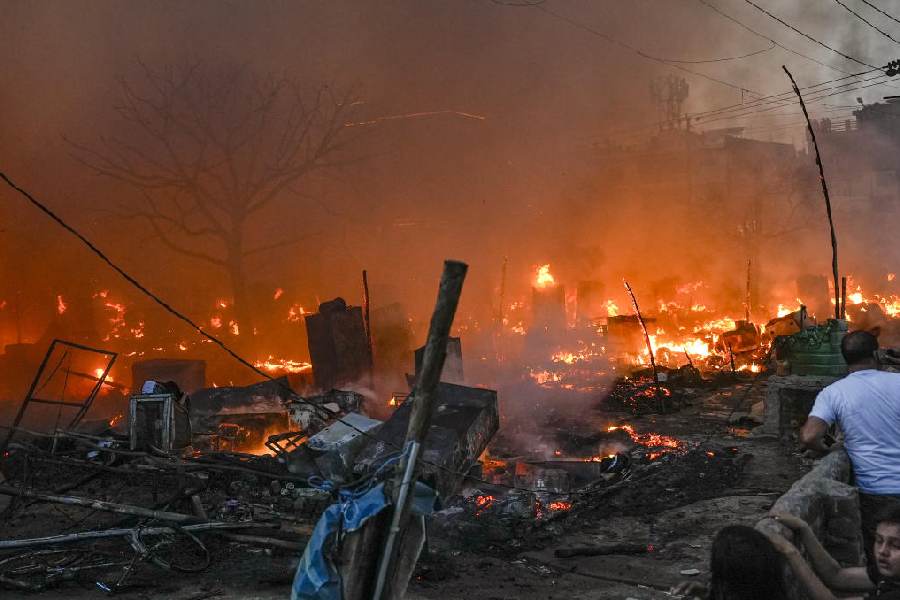 Smoke and flames billow out after a fire broke out at a slum cluster, destroying about 200 shanties, in the Vikas Nagar area, Lucknow, Wednesday, April 15, 2026.