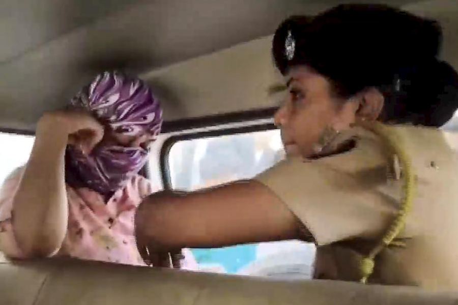 Police official detain a senior employee of the IT firm in Nashik, Wednesday, April 15, 2026.