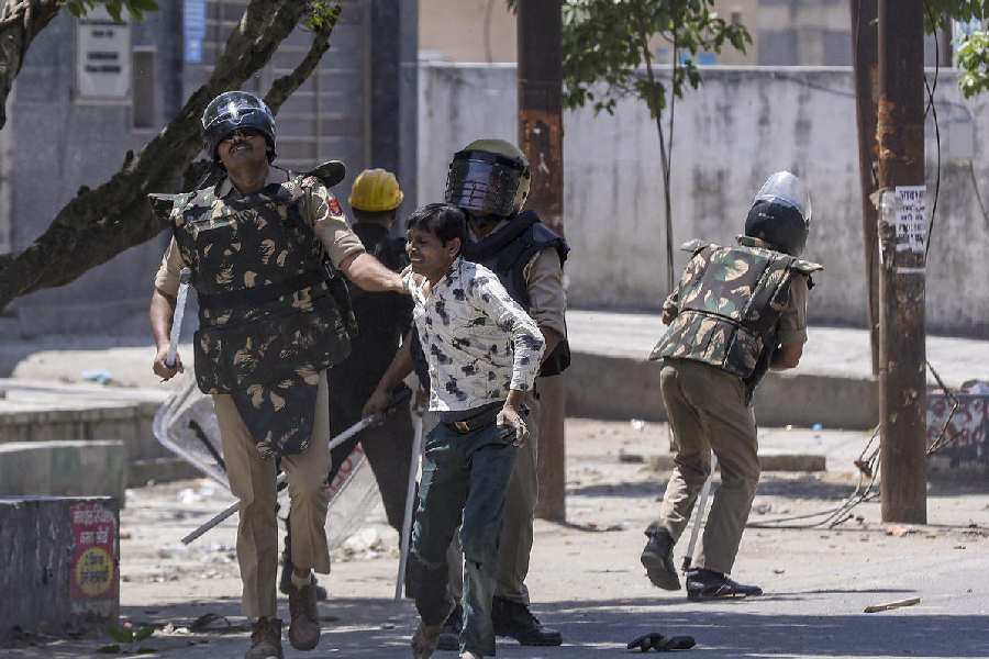 Security personnel detain a factory worker during a protest demanding a hike in wages, in Noida, Gautam Buddh Nagar district, Uttar Pradesh, Monday, April 13, 2026. The protest carried incidents of arson, vandalism and stone-pelting reported from Phase-2 and Sector 60 areas, police said.