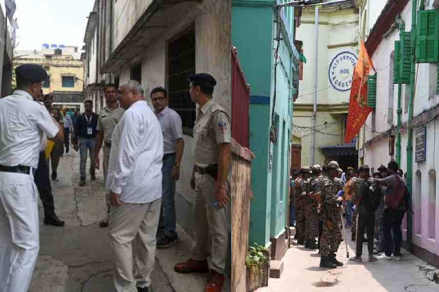 Randhir Kumar (in white, picture left), DEO of Calcutta South, visits polling booths in narrow lanes of Kidderpore along with central force personnel and police officers on Thursday. Pictures by Sanat Kr Sinha