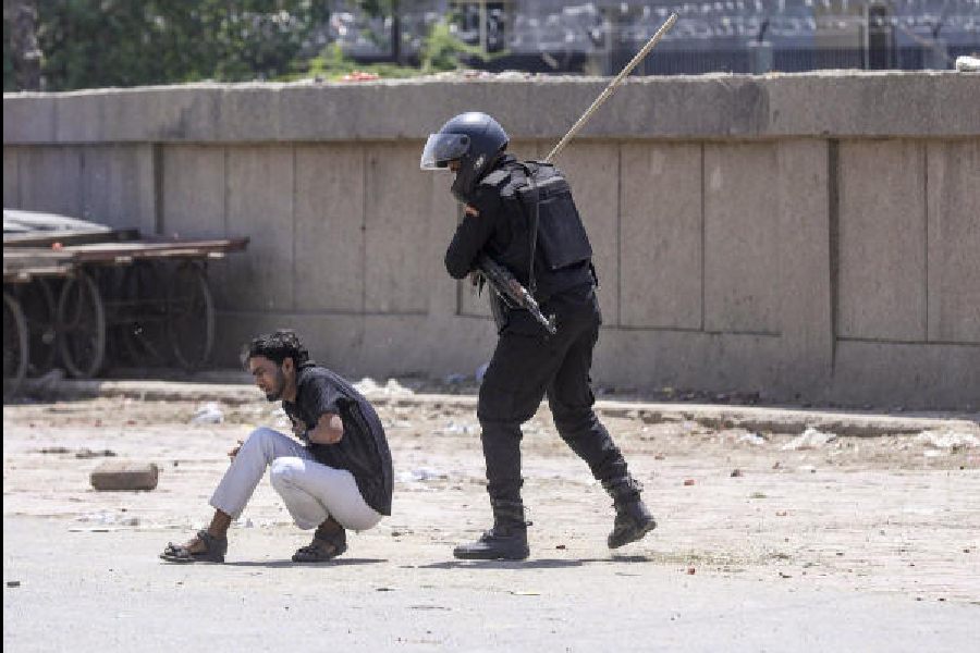 A security officer aims his baton at a protester in Noida on Monday.