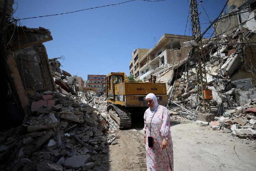 A woman walks at the site of an Israeli strike carried out before a 10-day ceasefire between Lebanon and Israel went into effect, in Tyre, Lebanon, April 17, 2026.