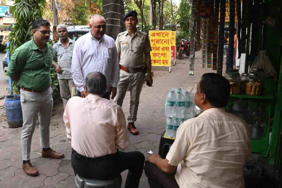 DEO Randhir Kumar (in white) speaks to voters at a tea stall in Bhabanipur on Friday. (Bishwarup Dutta)
