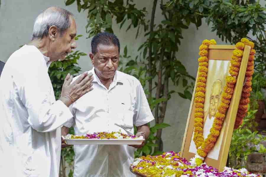 BJD president Naveen Patnaik pays tribute to the portrait of his father Biju Patnaik on the latter’s death anniversary, at his residence in New Delhi on Friday.