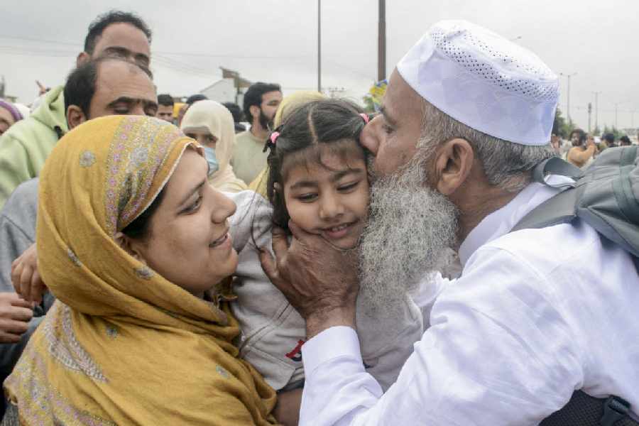 A pilgrim embraces a child as the first batch of Hajj pilgrims leave for Mecca, Saudi Arabia, at Hajj House, in Srinagar, Jammu and Kashmir, Saturday, April 18, 2026.