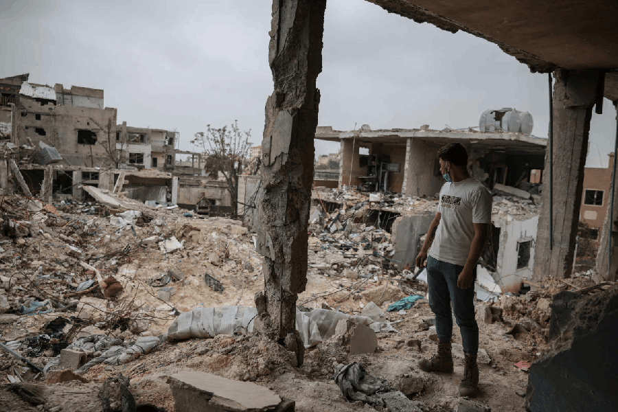 A relative looks at the destruction from the house of Zahra Eid, destroyed by Israeli strikes, while displaced people return to their villages, following the ceasefire between Lebanon and Israel, in Tayr Debba, south Lebanon, April 18, 2026.