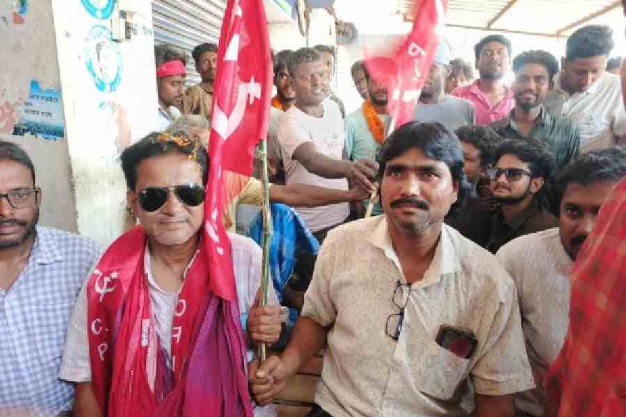 CPM’s Domkal candidate Mostafijur Rahaman aka Rana (left) hands over the party flag to Trinamool turncoat Enamul Malitha in Murshidabad’s Domkal on Friday.  Picture by Abdul Halim
