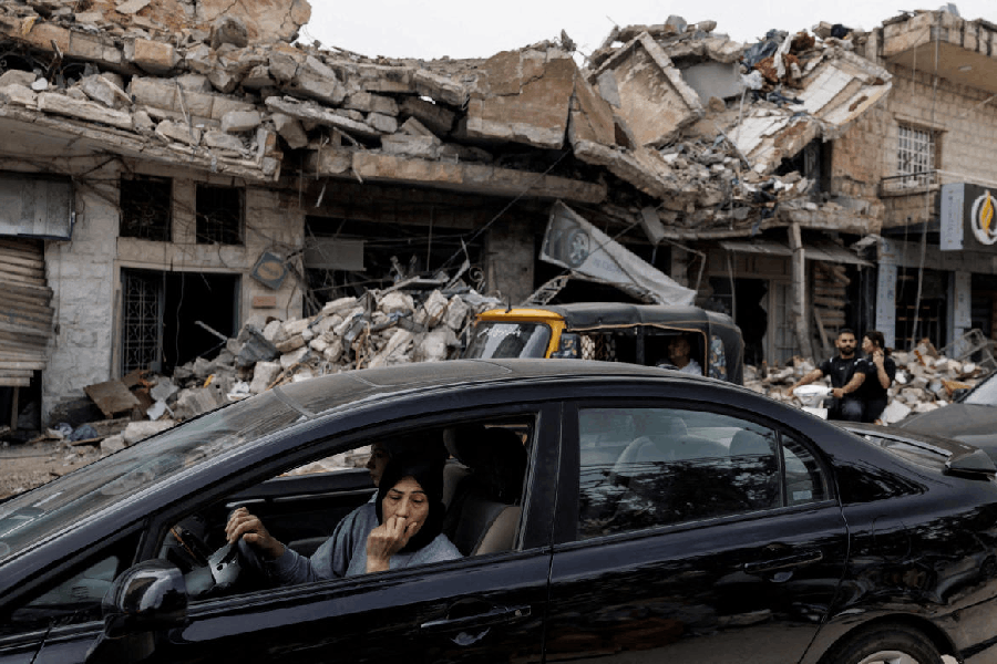 A displaced resident looks out at destruction caused by Israeli strikes as she drives home following a 10-day ceasefire between Lebanon and Israel that went into effect, in Nabatieh, Lebanon, April 18, 2026.