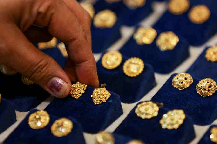 A woman picks a gold earring at a jewellery shop in the old quarters of Delhi, India, May 24, 2023.