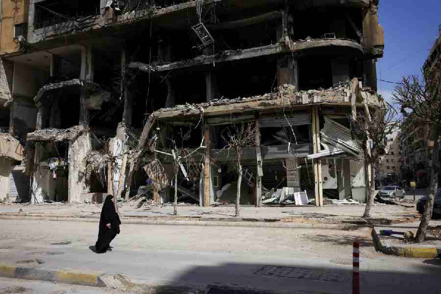 A woman walks past damaged buildings amid a 10-day ceasefire between Lebanon and Israel, in the southern suburbs of Beirut, Lebanon, April 20, 2026.