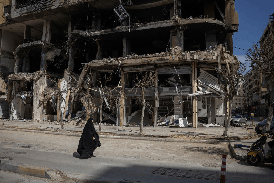 A woman walks past damaged buildings amid a 10-day ceasefire between Lebanon and Israel, in the southern suburbs of Beirut, Lebanon, April 20, 2026.