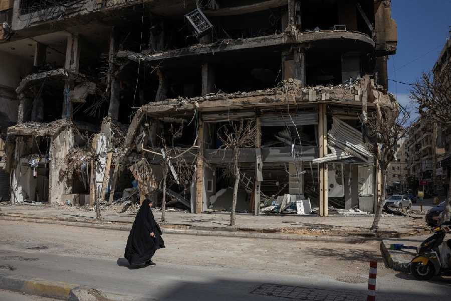 A woman walks past damaged buildings amid a 10-day ceasefire between Lebanon and Israel, in the southern suburbs of Beirut, Lebanon, April 20, 2026.