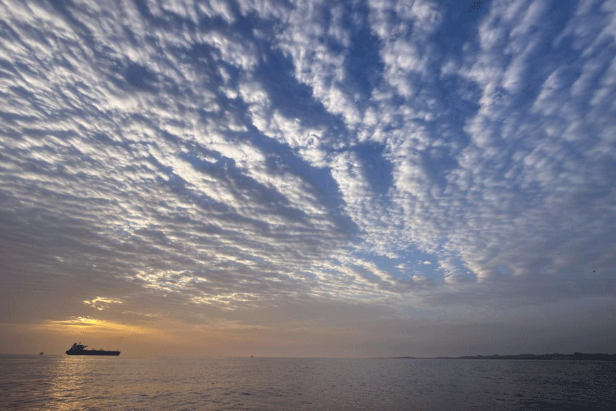 The sun rises behind a tanker anchored in the Strait of Hormuz off the coast of Qeshm Island, Iran, Saturday, April 18, 2026.