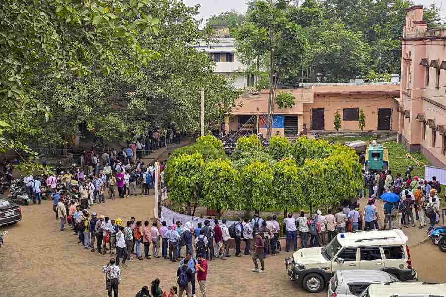 Polling personnel wait in queues to cast their votes through postal ballots ahead of the West Bengal Assembly elections, in Suri, Birbhum district, Friday, April 17, 2026.