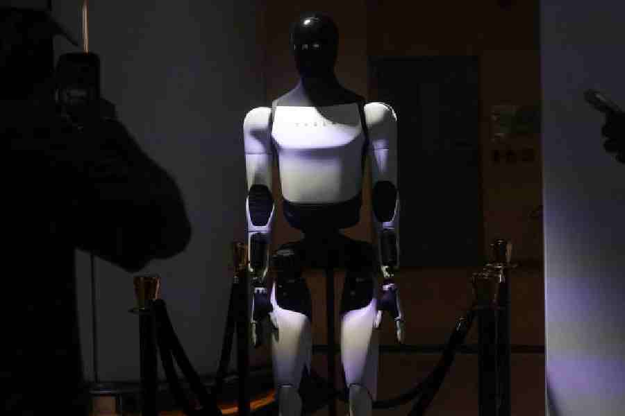 A man takes a picture of Optimus, a robot created by Tesla during a launch event for the Model Y L variant in Mumbai, India, April 22, 2026.