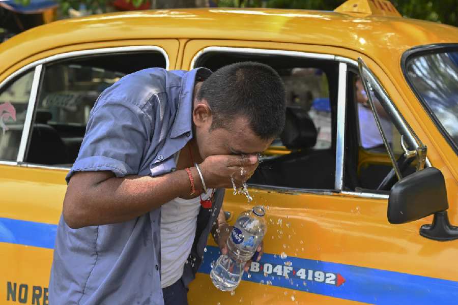 A driver splashes water on his face to get relief from the scorching heat on a hot summer day, in Kolkata, Monday, June 10, 2024.