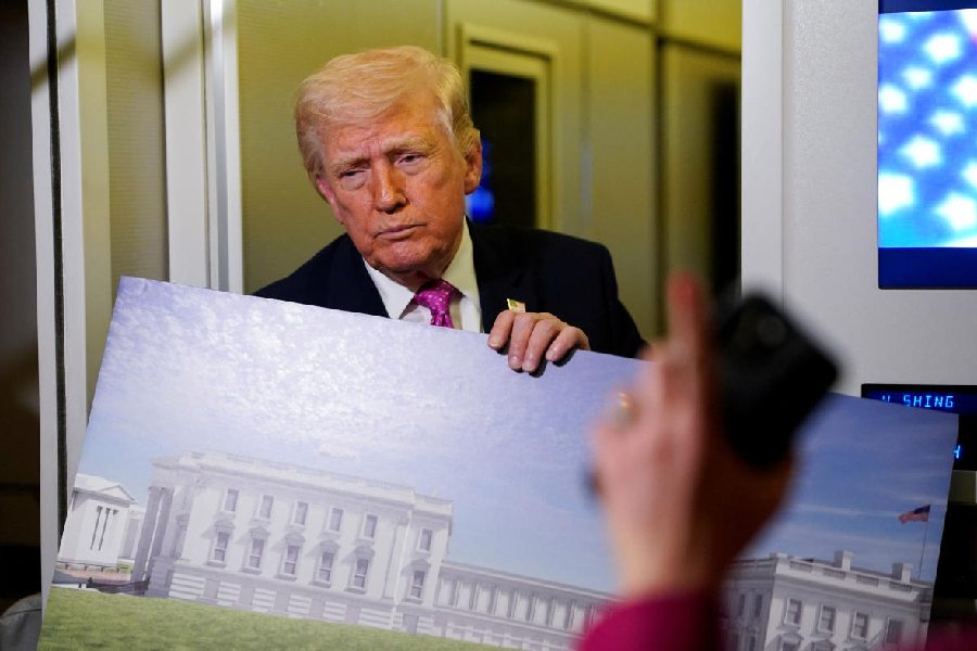A member of the media raises her hand for a question as U.S. President Donald Trump talks while holding up renderings of the planned White House ballroom, aboard Air Force One en route to Joint Base Andrews, Maryland, U.S., March 29, 2026.