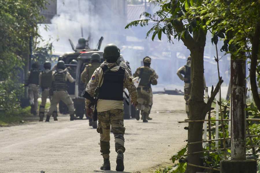 Security personnel fire tear gas shells to disperse people advancing towards the BDO office, in Thoubal district of Manipur, Tuesday, April 21, 2026.