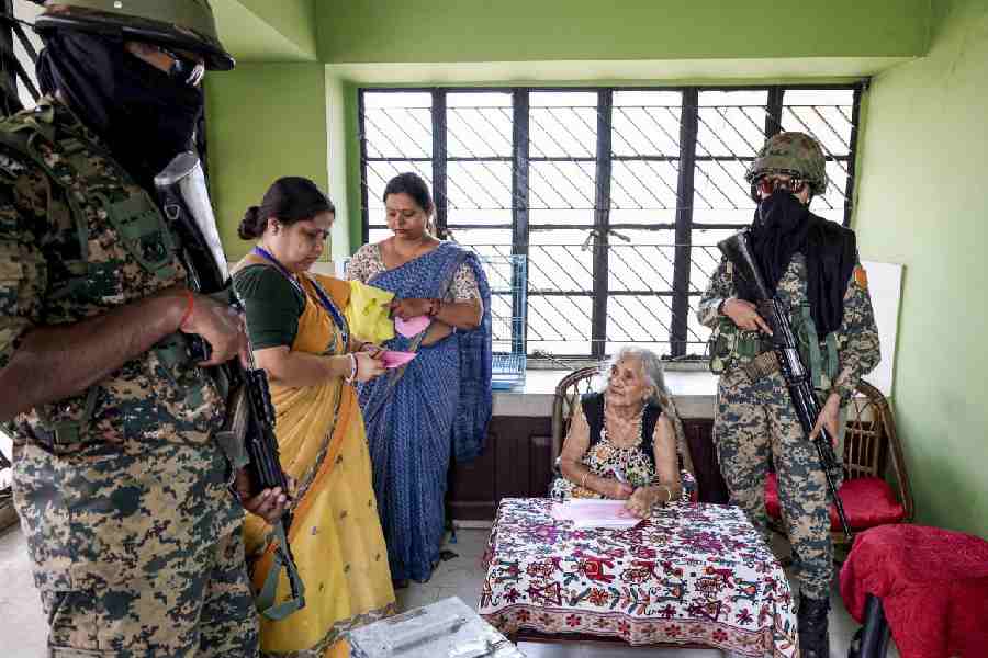 Polling officials assist an elderly resident voting at home in Bolpur, Birbhum, last week.