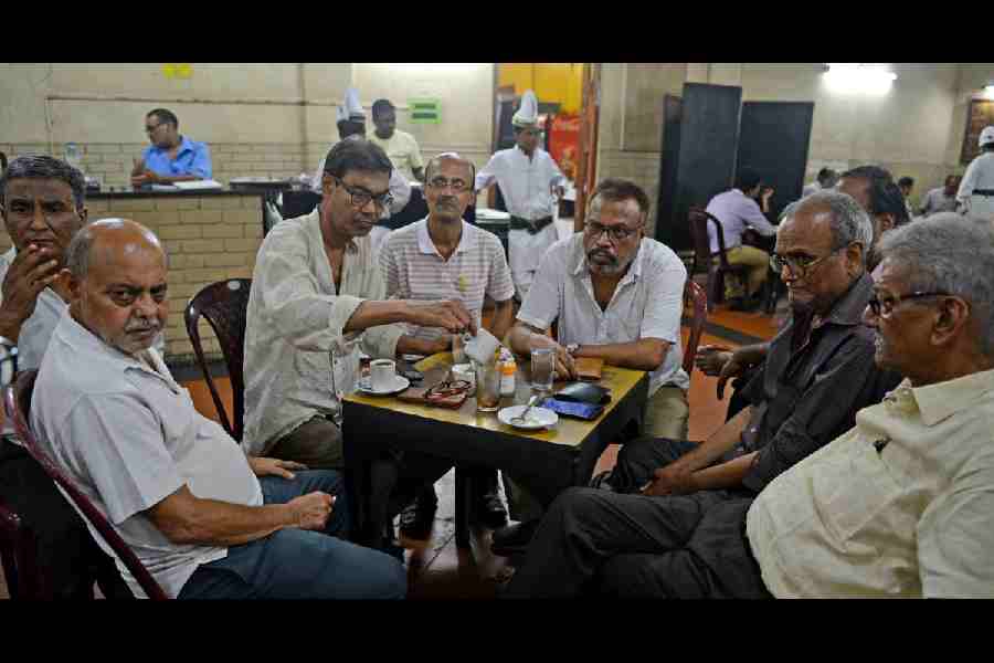 Four people having conversations at Indian Coffee House, Kolkata.