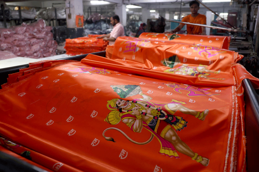 Employees fold printed polyester fabric for packaging inside Bindal Silk Mills in Surat.