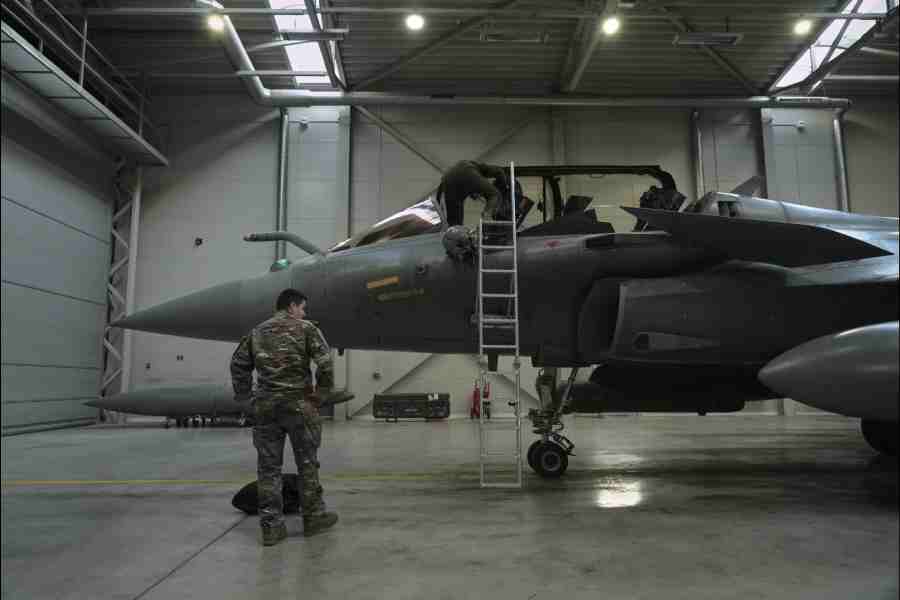 A flight-crew member climbs into the cockpit of a French air force Rafale fighter jet stationed on a NATO air-policing mission at the Siauliai Air Base in Lithuania as another member of the French detachment stands at the foot of the ladder on Sunday, April 19, 2026
