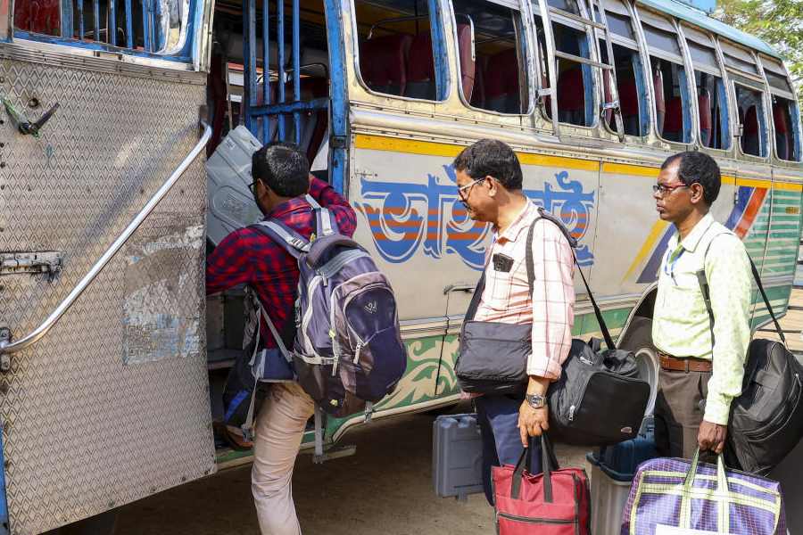 Polling officials carry electoral material as they board a bus for their respective polling stations from a distribution centre, ahead of the West Bengal Assembly elections, in Birbhum district, Wednesday, April 22, 2026.